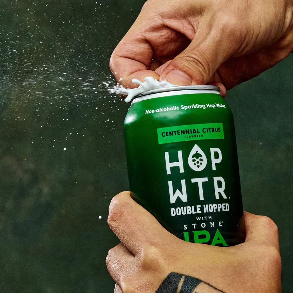 Hands opening a HOPWTR Centennial Citrus can with a splash